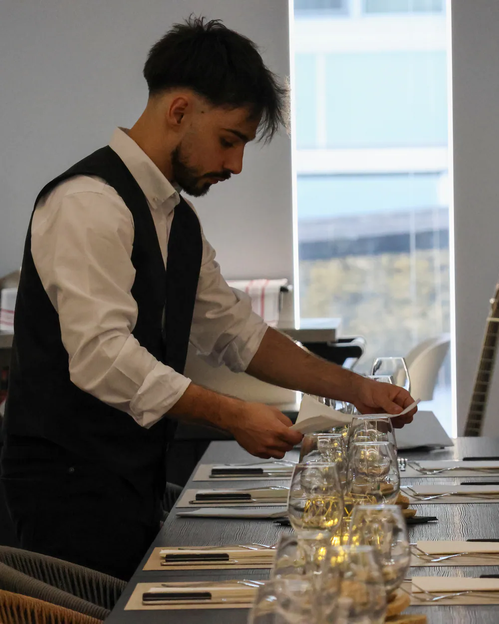 Elemento da equipa a preparar uma mesa no Fusion Bistrô
